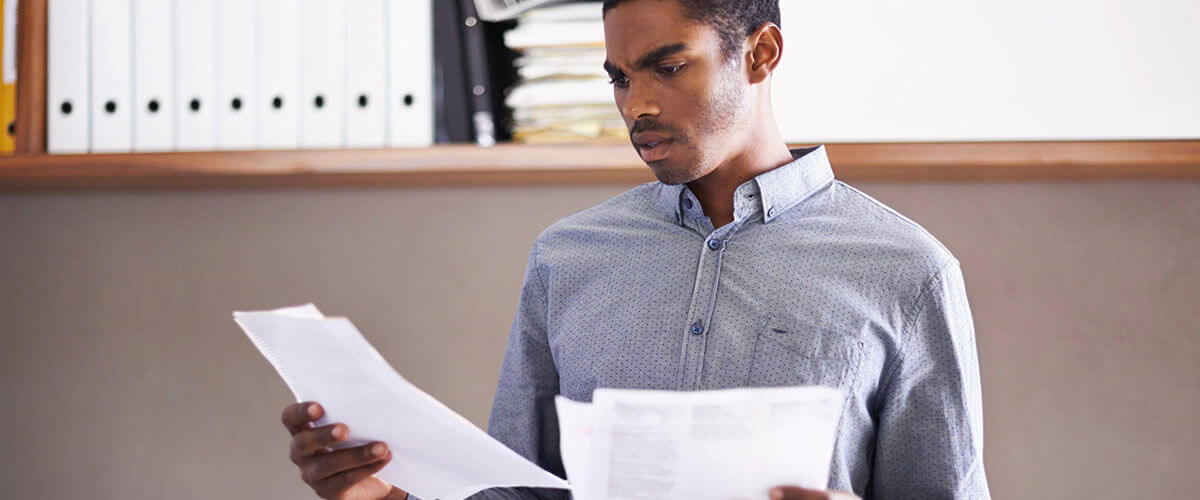 Man looks confused checking the mortgage origination fee on his loan statement