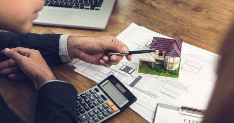 Man pointing at house model with pen