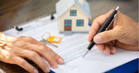 Hand with pen signing a mortgage contract