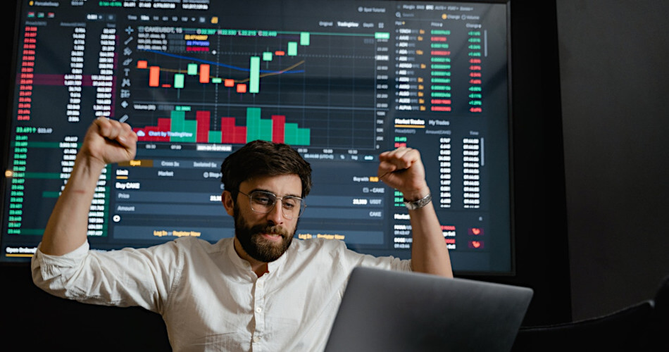 crypto trading raises arms in sign of success in front of large trading data chart