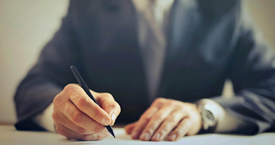 Man in a business suit signing a form offering ancillary benefits to employees