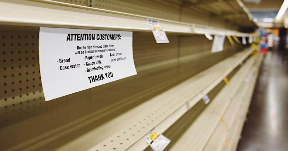 empty store shelves with a notice to customers that they can only buy two of each product