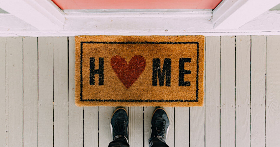 welcome mat with word home with heart symbol in place of the o in home