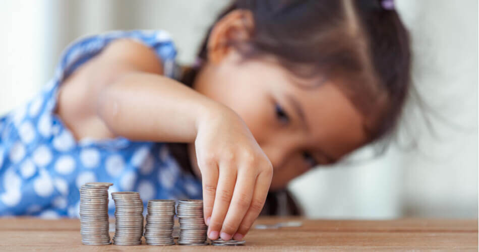Little girl stacking dimes on a table
