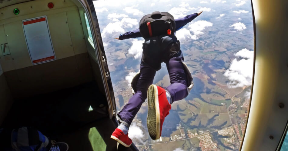 Person jumping out of an airplane to skydive