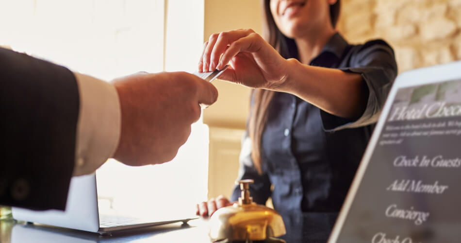 Man giving credit card to a hotel front desk employee