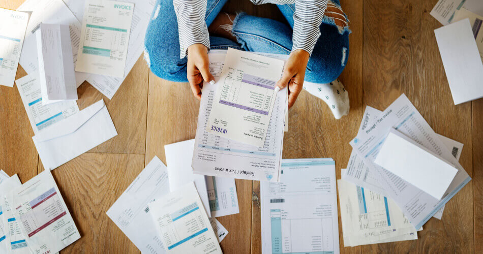 Person sitting cross legged surrounded by tax documents