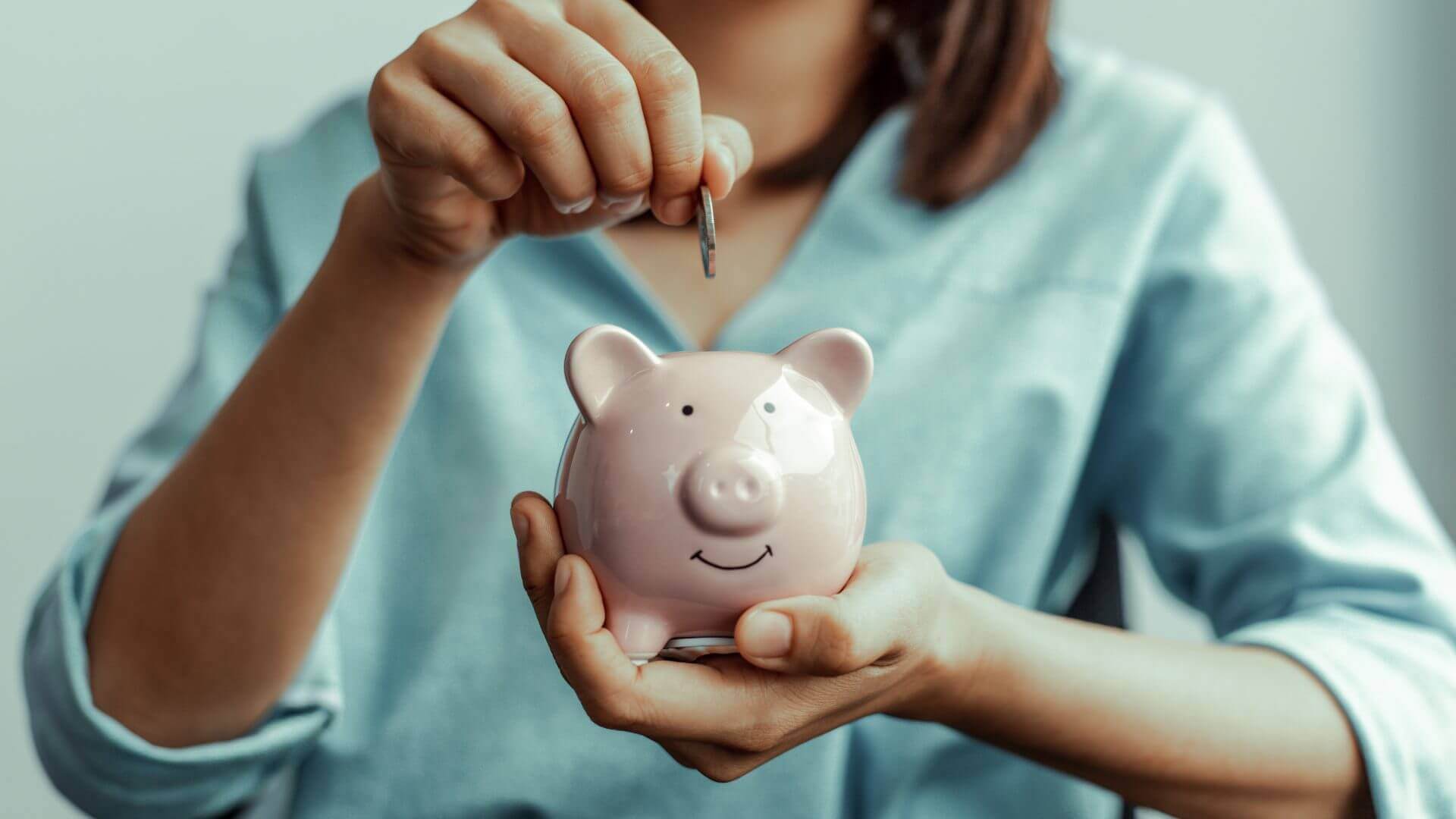 Woman adding money from her $93/hour job to her piggy bank