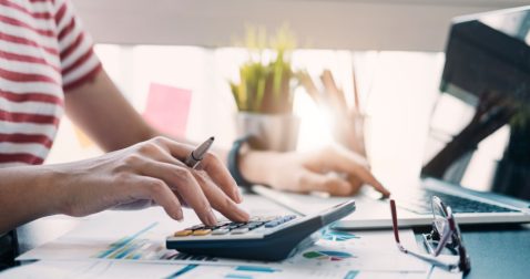 Person reviewing their budget and calculating how much $19k/year an hour would equal