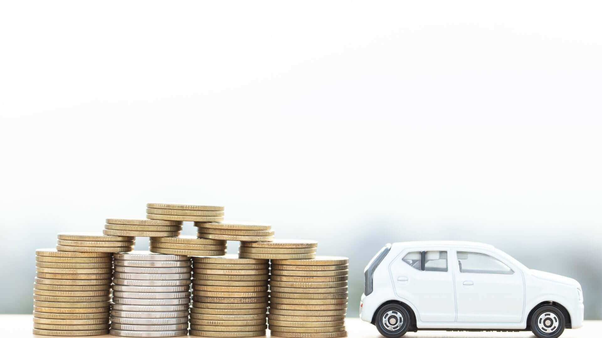 A stack of coins next to a small car model representing the money you can deduct from a vehicle used for business