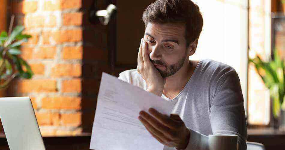 Man looking discouraged as he reviews a paper