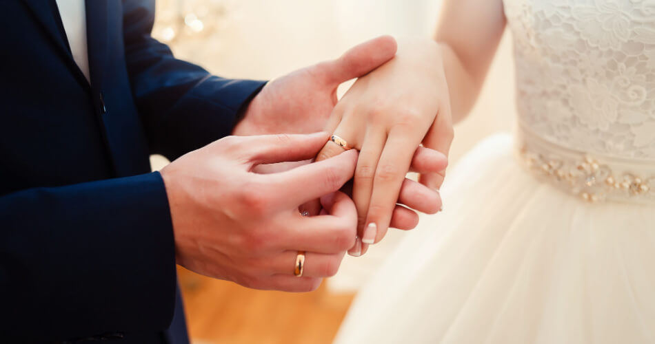 Couple exchanging wedding bands after finding out how much you should spend on a wedding ring
