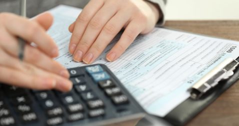 Someone reviewing their tax documents before getting online with a tax expert through TurboTax Live Deluxe, Full Service, Premier, or Basic