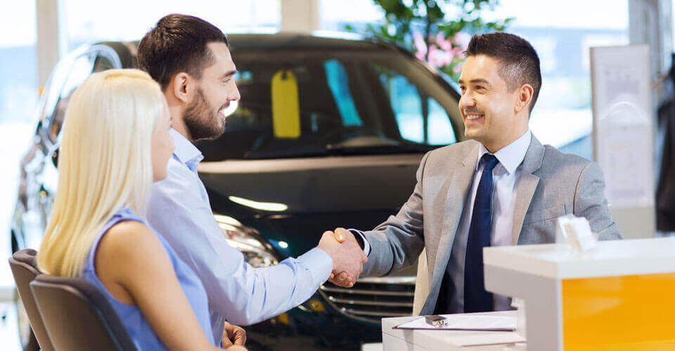 Customer shaking hands with a car salesman