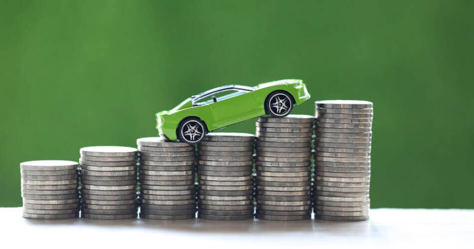 Green toy car driving up stacks of coins