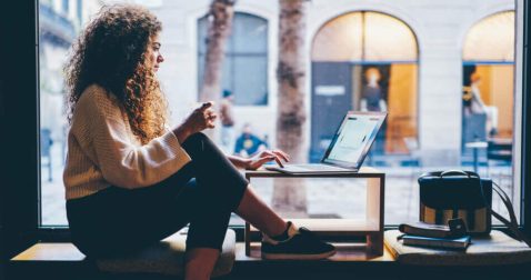 Young freelancer reviewing no-income verification mortgages on her laptop